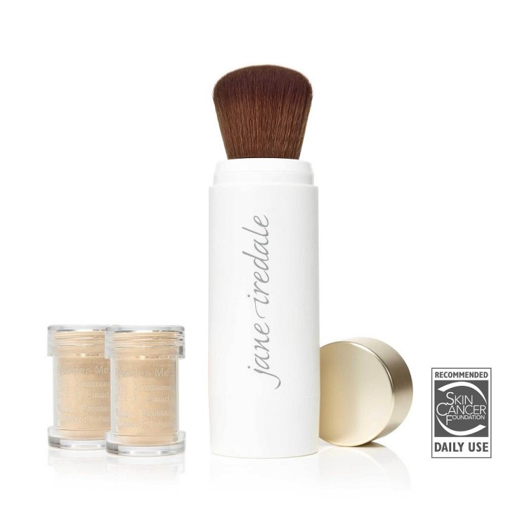 Na obrázku je vidět štětec integrovaný s sypkým pudrem značky Jane Iredale Powder-Me SPF. Produkt se skládá z elegantní bílé nádobky s měkkým, zaobleným štětcem a dvou průhledných náplní s ochranným pudrem.