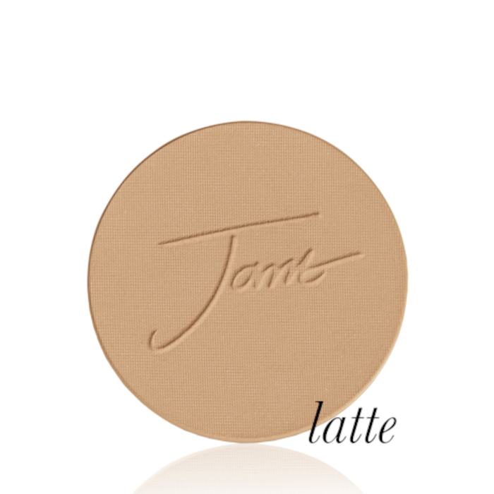 Kulatý lisovaný pudr na obličej značky Jane Iredale v odstínu Latte: tmavě béžový s teplým kávovým podtónem s vyraženým logem Jane Iredale.