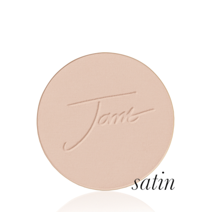 Kulatý lisovaný pudr na obličej značky Jane Iredale v odstínu Satin jemně béžový s lehkou rovnováhou mezi žlutou a růžovou barvou s vyraženým logem Jane Iredale.