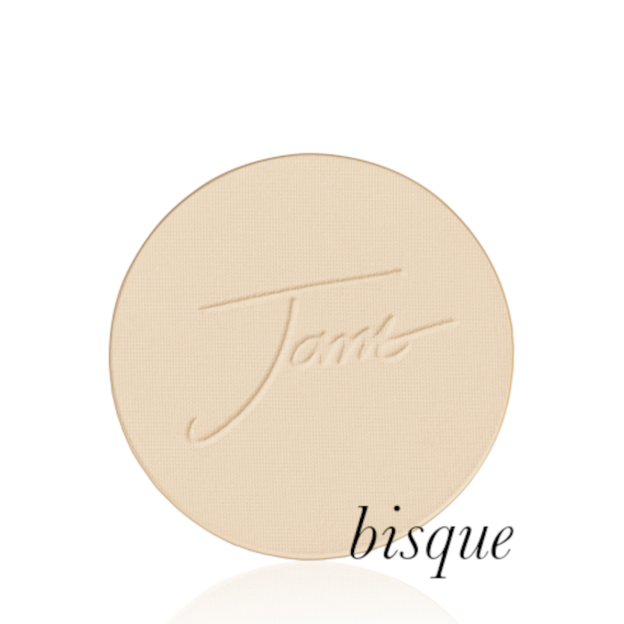 Kulatý lisovaný pudr na obličej značky Jane Iredale v odstínu Bisque: Světle béžový s neutrálním podtónem s vyraženým logem Jane Iredale.