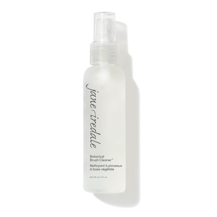 Na obrázku je vidět průhledná lahvička s rozprašovačem značky jane iredale. Na etiketě je uvedeno „Botanical Brush Cleaner“, tedy botanický čisticí přípravek na štětce. Slouží k rychlému a účinnému čištění štětců na make-up.