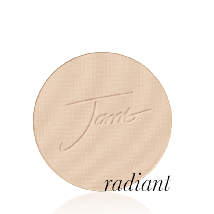 Kulatý lisovaný pudr na obličej značky Jane Iredale v odstínu Radiant: Světlý odstín s jemným zlatým leskem s vyraženým logem Jane Iredale.