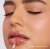 Na obrázku je modelka s rty nalíčenými leskem Jane Iredale v odstínu Nectar. Nectar je teplý broskvový nude odstín s jemným leskem, který krásně doplňuje opálenou pleť.