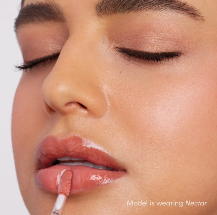 Na obrázku je modelka s rty nalíčenými leskem Jane Iredale v odstínu Nectar. Nectar je teplý broskvový nude odstín s jemným leskem, který krásně doplňuje opálenou pleť.