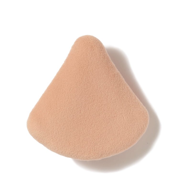 Na zdjęciu jest gąbka do makijażu marki jane iredale,  służąca do nakładania podkładu. Beżowy materiał,  trójkątny kształt – idealny do precyzyjnej aplikacji w okolicach oczu i nosa.