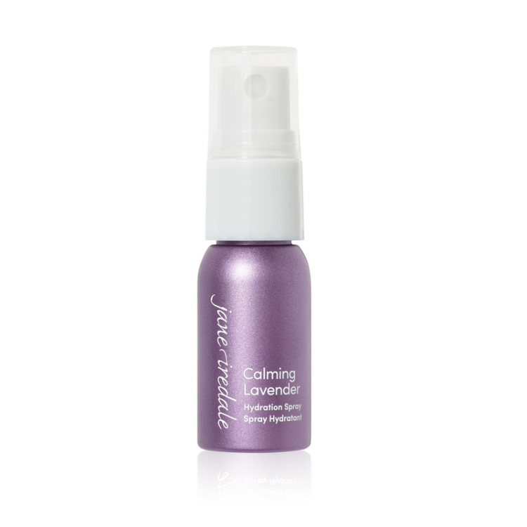 Na fotografii je elegantní fialová mini lahvička s bílým rozprašovačem Jane Iredale Lavender Hydration Spray MINI o obsahu 12 ml. Produkt má označení ECOCERT, které potvrzuje organický a přírodní původ jeho složek.