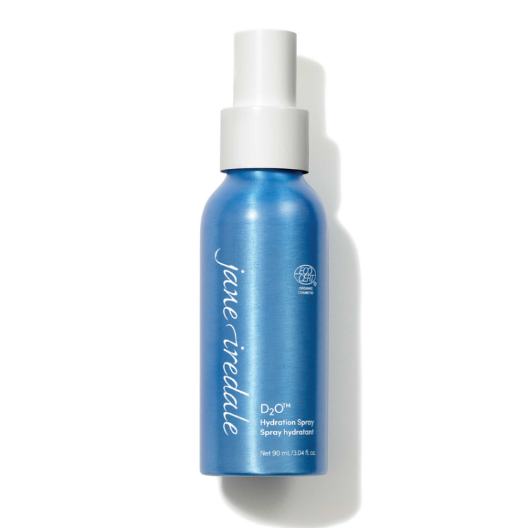 Na fotografii je elegantní modrá lahvička s bílým rozprašovačem vody Jane Iredale D2O Hydration Spray o obsahu 90 ml. Produkt má označení ECOCERT, které potvrzuje organický a přírodní původ jeho složek.