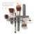 Na obrázku je kolekce štětců na make-up značky jane iredale, uspořádaných křížem na světlém pozadí. Štětce mají matné, grafitové rukojeti s logem značky, saténově zlaté objímky a hnědo-bílé, nadýchané štětiny.