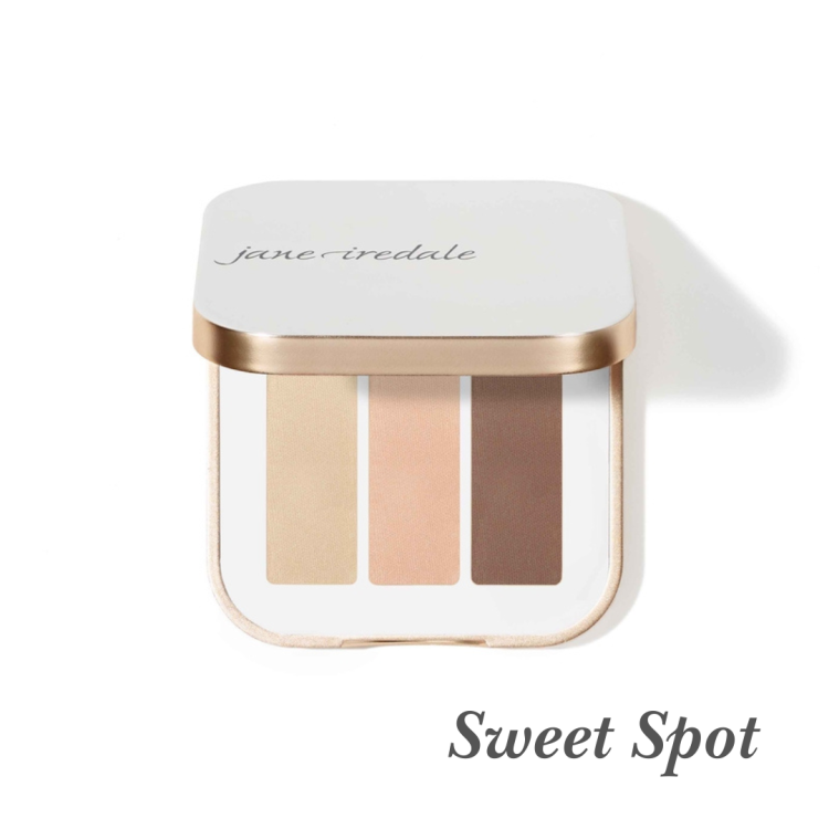 Na fotografii je trojitá paletka očních stínů Jane Iredale v odstínu Sweet Spot. Obsahuje tři stíny v teplých, neutrálních odstínech, ideálních pro každodenní líčení: matný krémový, matný broskvově nude a matný teplý hnědý.