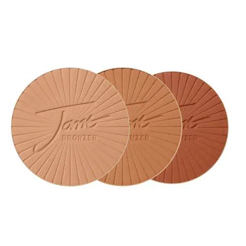 Na obrázku jsou vidět tři lisované kulaté bronzery značky Jane Iredale PureBronze. Jsou uspořádány zleva v odstínech Light, Medium a Dark.