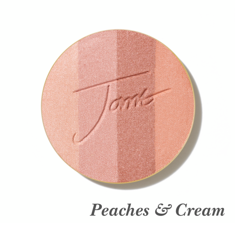 Kulatý, lisovaný multifunkční bronzer na obličej značky Jane Iredale v odstínu Peaches & Cream s vyraženým logem Jane Iredale. Bronzer se skládá ze čtyř odstínů, které jsou na grafice slovně popsány.