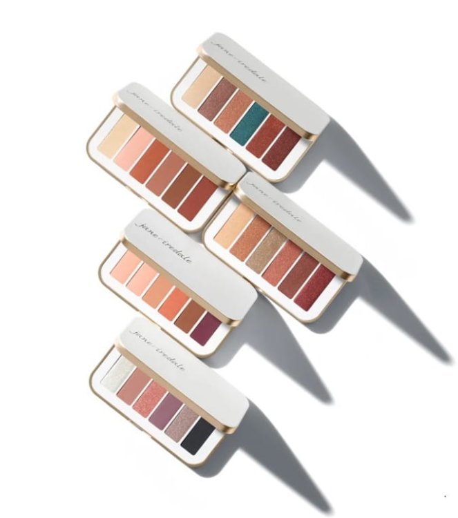 Na fotografii je 5 paletek očních stínů značky Jane Iredale. Každá obsahuje šest stínů v konkrétní barevné kombinaci. Paletky mají elegantní balení se zrcátkem ve zlatobílé barevnosti. Jsou uspořádány vedle sebe.