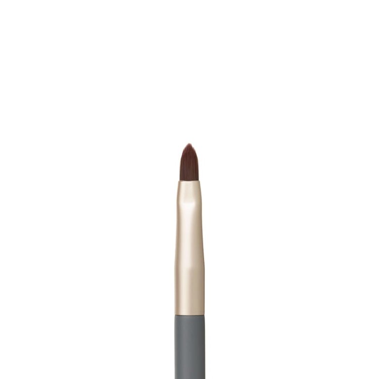 Na obrázku je detail štětce na rty z kolekce jane iredale. Má precizní, špičatý tvar štětin, který umožňuje přesné vykreslení kontur rtů a rovnoměrné vyplnění barvou.