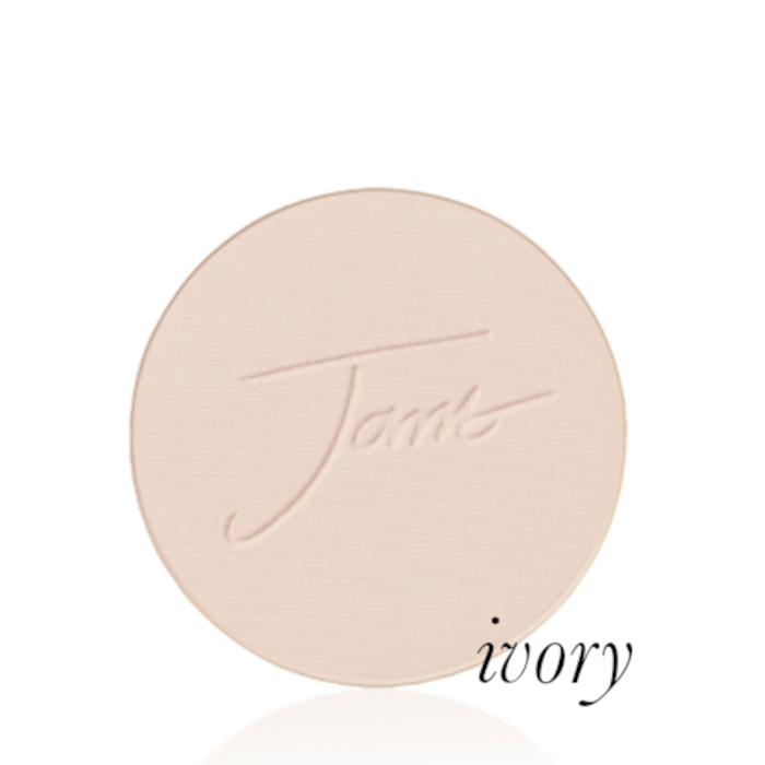 Kulatý lisovaný pudr na obličej značky Jane Iredale v odstínu Ivory: Velmi světlá béžová barva s chladným růžovým podtónem s vyraženým logem Jane Iredale.
