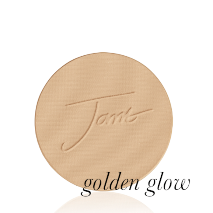 Kulatý lisovaný pudr na obličej značky Jane Iredale v odstínu Golden Glow: Střední odstín s teplým zlatavým podtónem s vyraženým logem Jane Iredale.