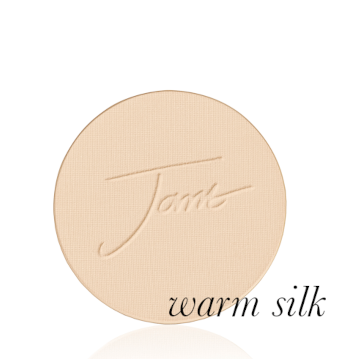 Kulatý lisovaný pudr na obličej značky Jane Iredale v odstínu Warm Silk: Světlá béžová s teplým žlutým podtónem s vyraženým logem Jane Iredale.