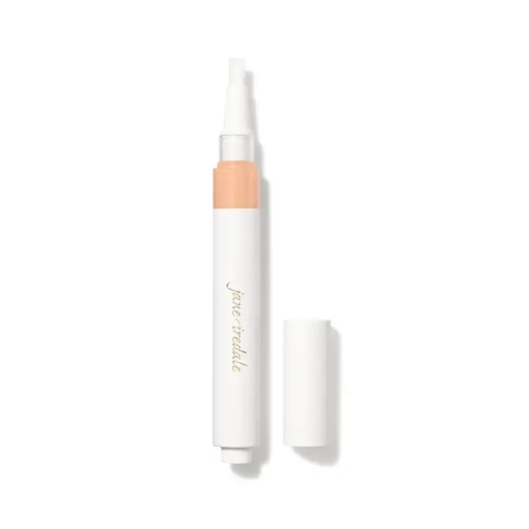 Na fotografii je korektor se štětečkovým aplikátorem značky jane iredale. Je vidět otočný obal s vestavěným aplikátorem ve formě štětečku a uzávěrem. Produkt je určen k rozjasnění očního okolí a zakrytí tmavých kruhů pod očima.