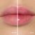 Fotografie typu „před a po“ zachycuje detail rtů modelky. Vlevo mají rty přirozenou, jemně růžovou barvu, vpravo po aplikaci oleje Jane Iredale Just Kissed Lip Oil získávají intenzivnější růžový odstín.