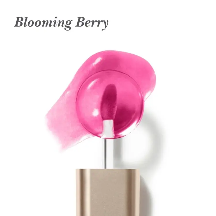 Na bílém pozadí je aplikátor oleje na rty Jane Iredale Just Kissed Lip Oil s měkkou, zaoblenou špičkou v intenzivní růžovo-bobulové barvě. V pozadí je vidět rozetřený vzorek oleje s transparentní, lesklou texturou v odstínu fuchsie.