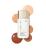 Na obrázku je Jane Iredale Glow Fixation SPF 40 Sheer Tint Skin Enhancer v bílém balení s aplikátorem. Kolem produktu jsou zobrazeny vzorky kosmetického přípravku v několika tónech – od světlých béžovo-broskvových až po hlubší, teplé hnědé odstíny.