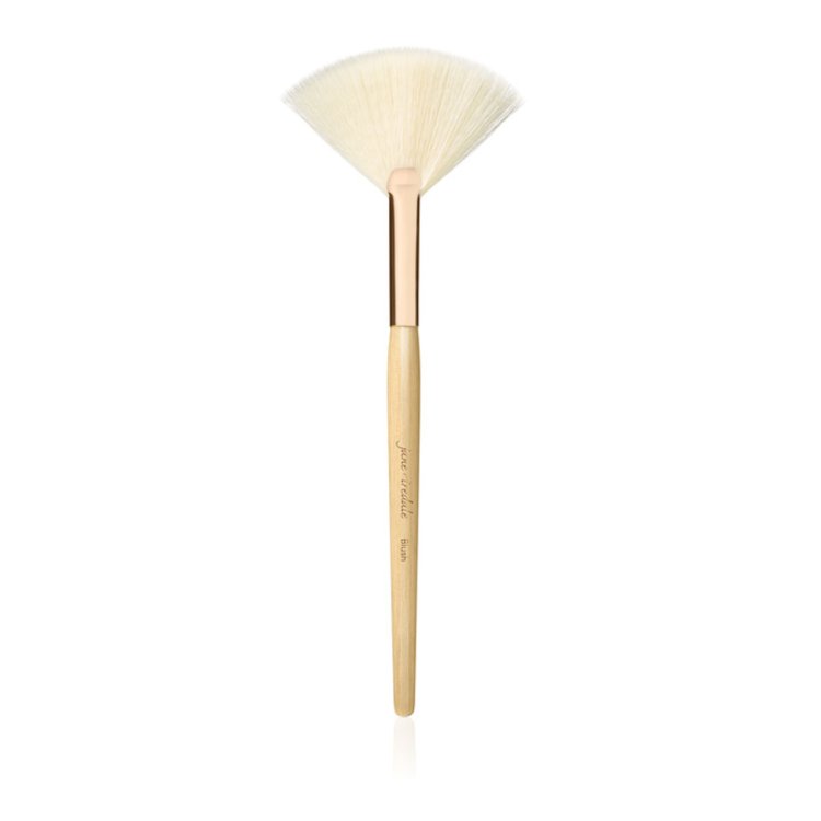 Na obrázku je vějířovitý štětec značky Jane Iredale. Jedná se o lehký, vějířový štětec se světlými štětinami, ideální pro aplikaci rozjasňovače, odstranění přebytečného pudru a konturování. Má štíhlou rukojeť z přírodního dřeva a zlatou objímku.