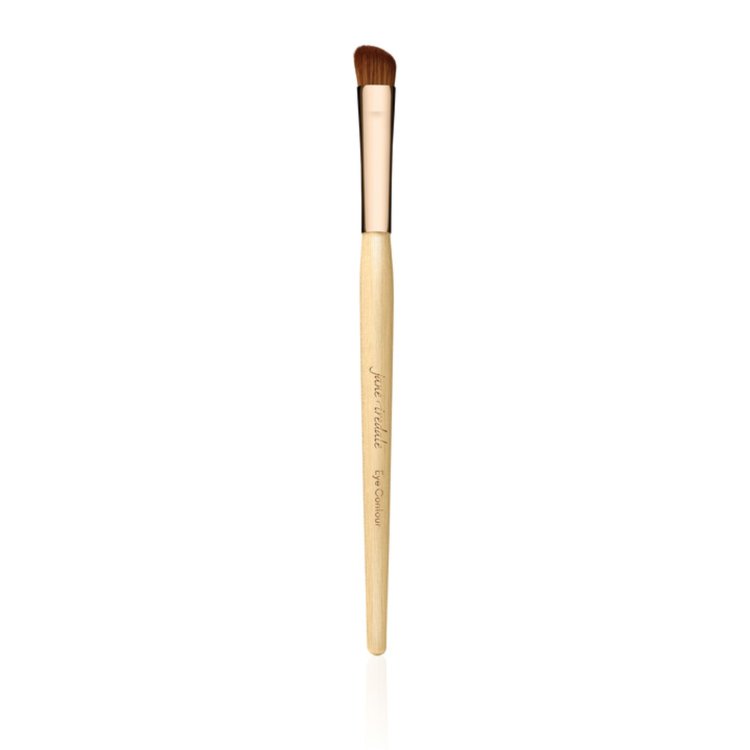 Na fotografii je štětec na oči od Jane Iredale. Štětec má dřevěnou rukojeť v přírodní barvě, zlatou objímku a krátké, husté, mírně zaoblené tmavé štětiny.